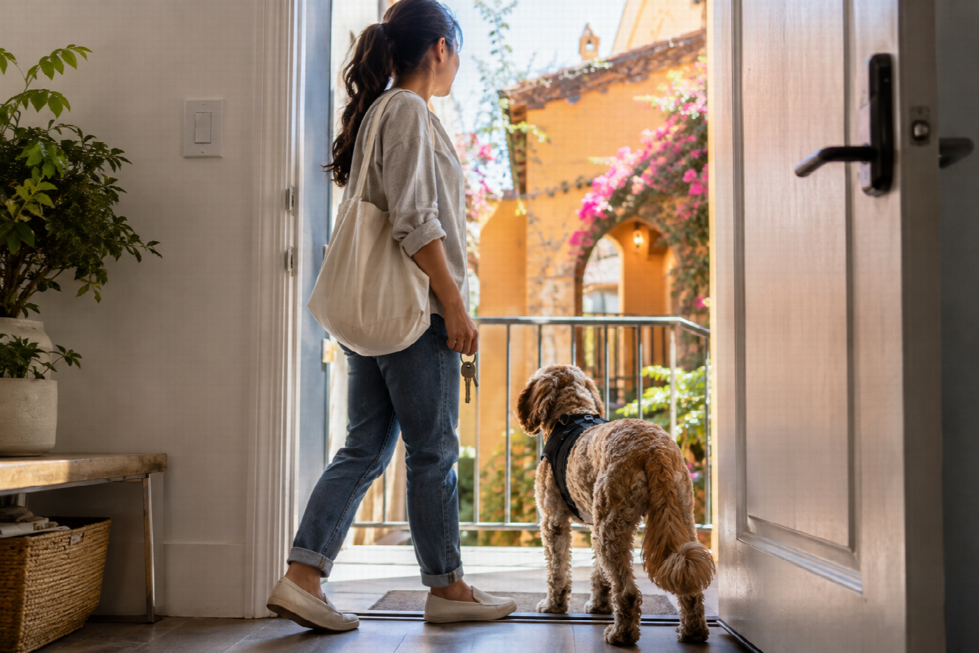 A tenant standing in the doorway of a California apartment with a calm dog beside them.